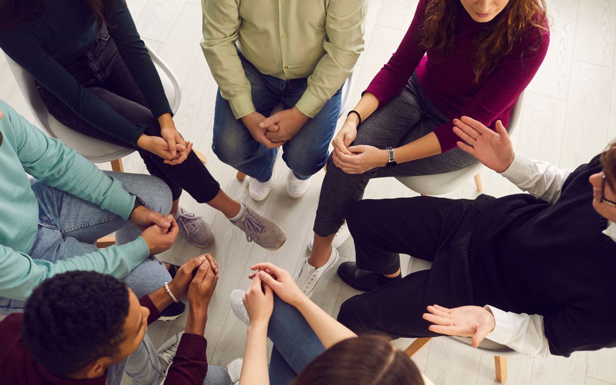 Group of people sitting in a circle during a support meeting.