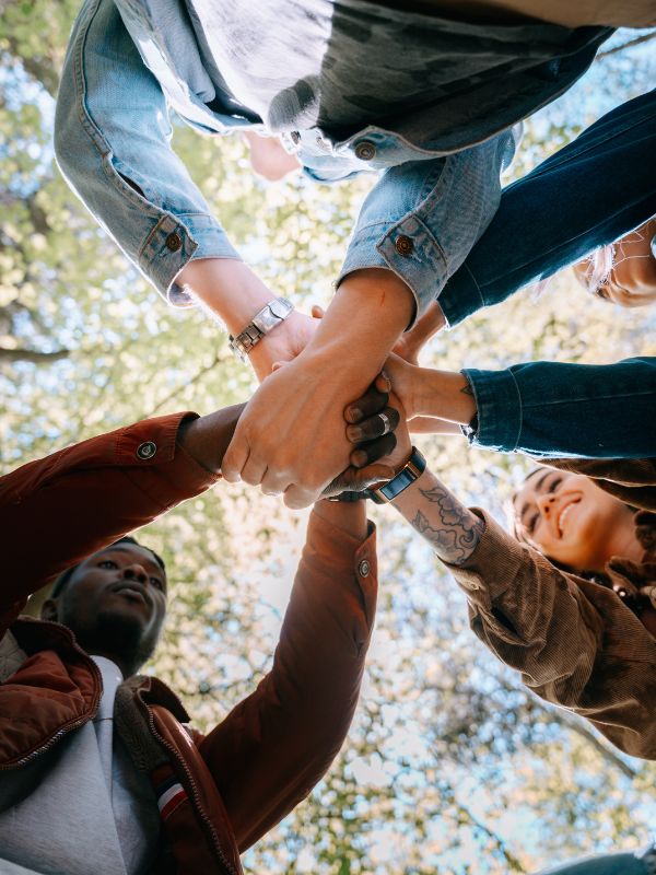 Group of friends clasping hands together